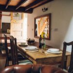 Dining table in Ty Hebog self catering holiday cottage with the front door entrance area in the background