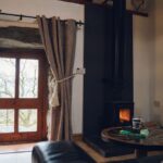 Sitting aLiving area with log burner - complimentary basket of logs providedrea in Ty Hebog cottage with comfortable seating and a log burner
