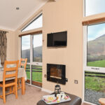Living and dining area with mountain views through the floor‑to‑ceiling windows.